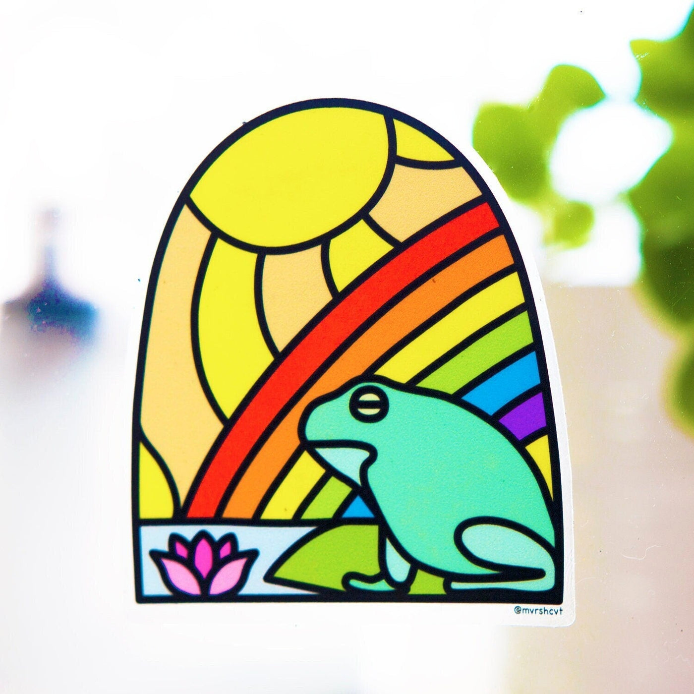 Colorful sicker with frog sitting on water and rainbow and sun design in a stained glass style